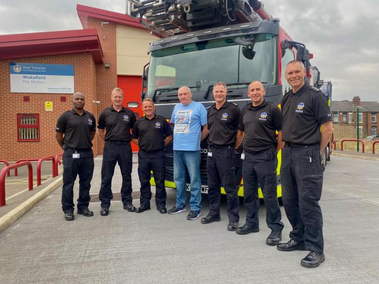 Wakefield Green Watch and Mr Whittaker standing in front of a fire aerial ladder platform